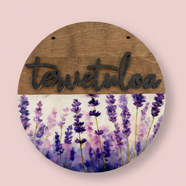 Kesäkukka teemainen ovikyltti tervetuloa-tekstillä.