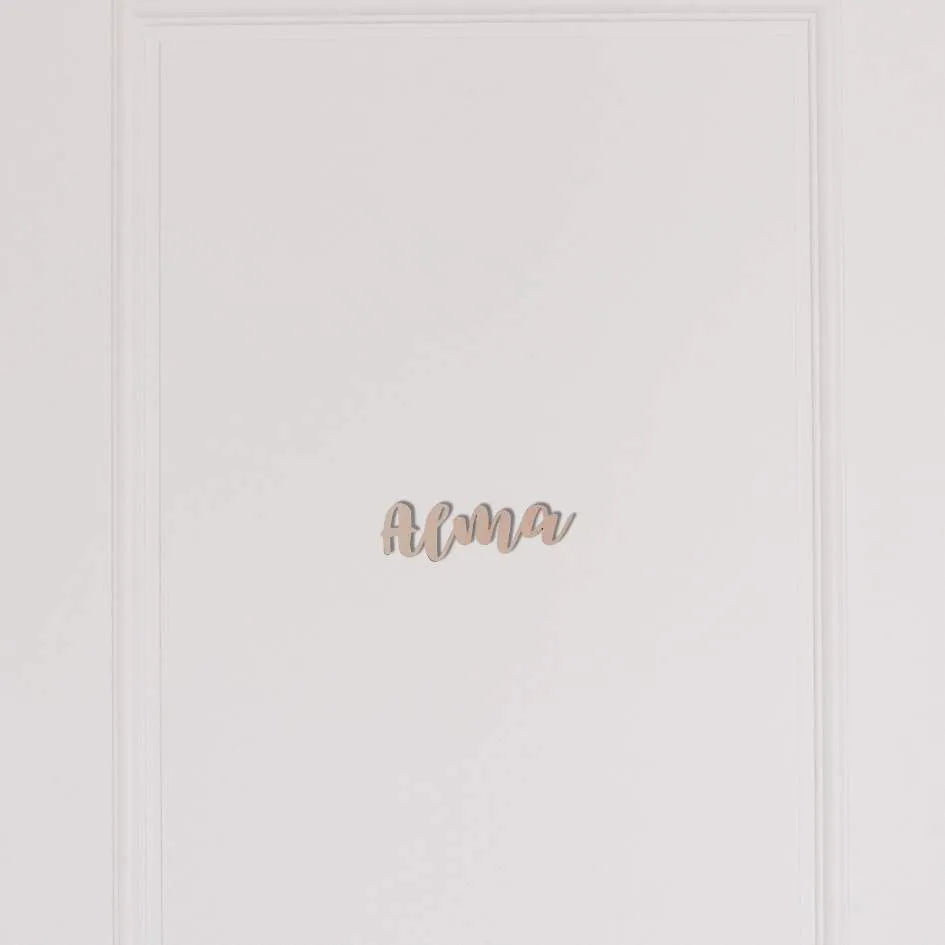 Puinen nimi lastenhuoneen oveen.