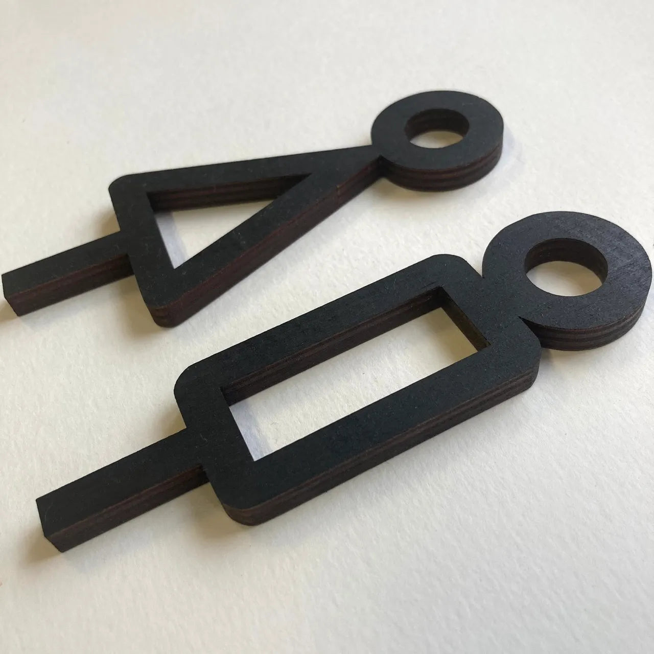 Puinen minimalistinen wc-kyltti toimiston sisustukseen.