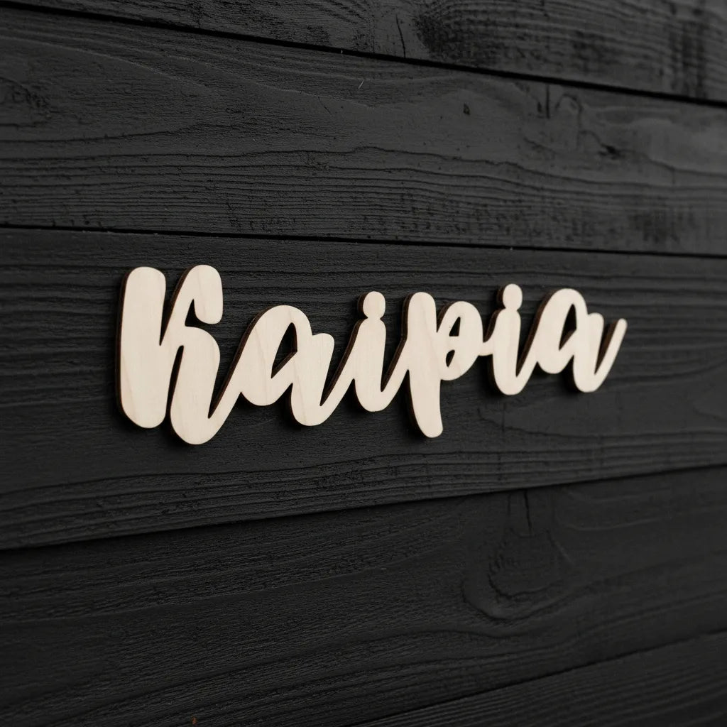 Puinen sukunimi-kyltti talonseinään tai oveen.