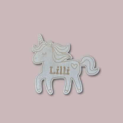 Puinen yksisarvinen lastenhuoneen oveen lapsen nimellä.