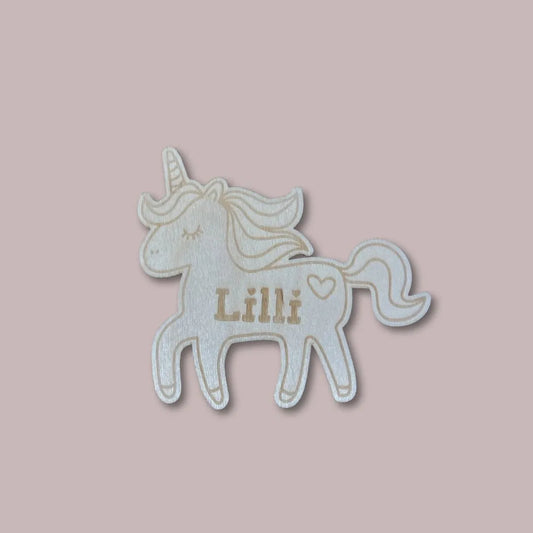 Puinen yksisarvinen lastenhuoneen oveen lapsen nimellä.